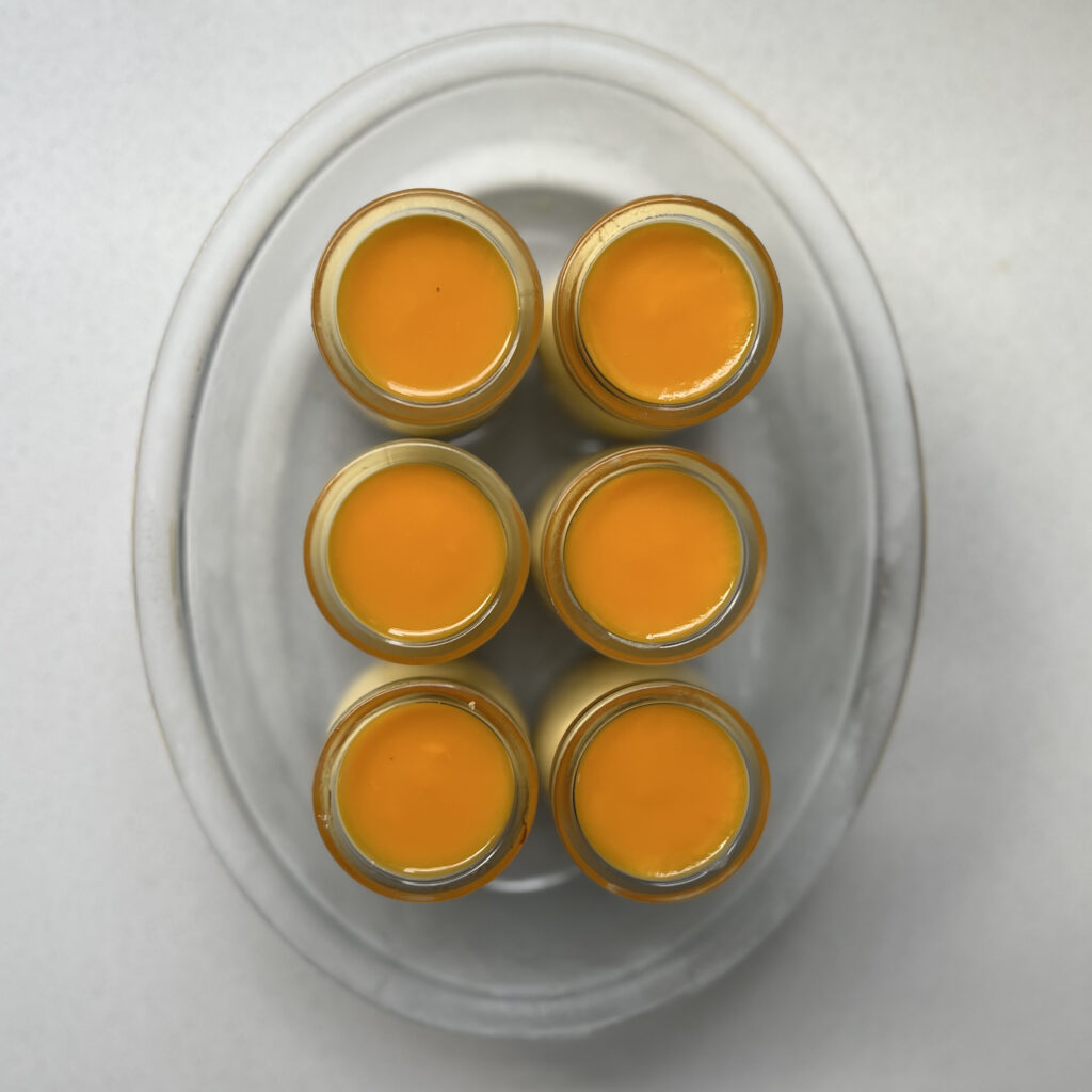 mango pulp topping on mini mango cheesecakes